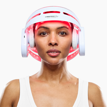 Woman using CurrentBody's Red Light Therapy Hair Growth Helmet on her head